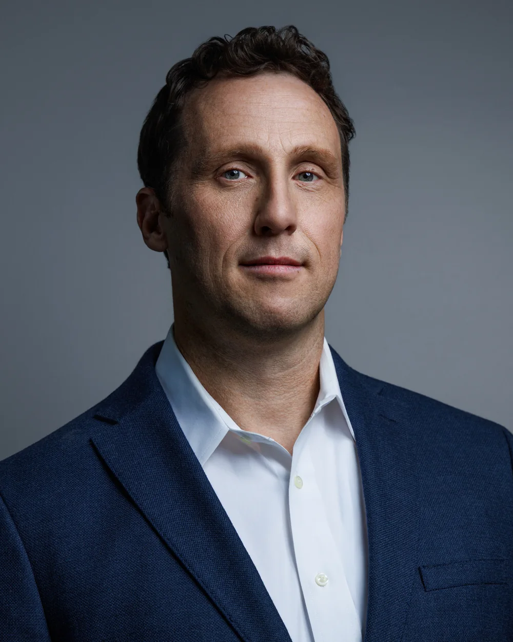 Alex West in a navy sport coat — studio portrait